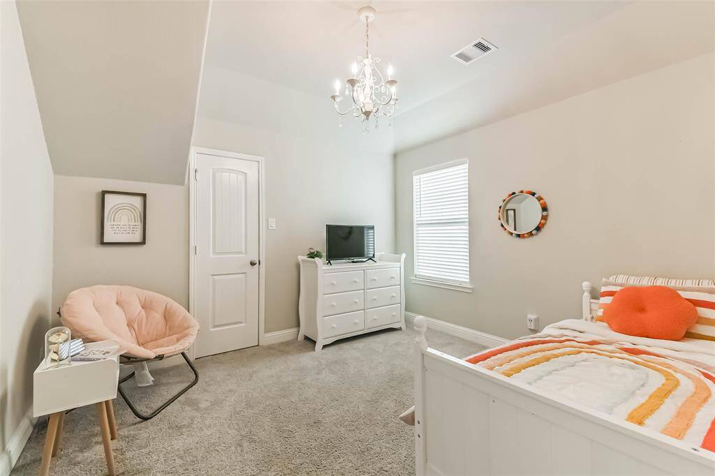 Fourth bedroom has upgraded mini-chandelier light fixture and huge walk-in closet with access to floored attic storage space.