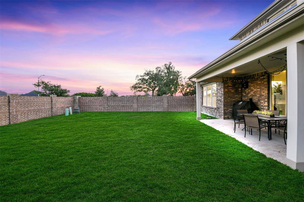 This view offers trees and sunsets over two sides of brick fence which are maintained by the HOA.