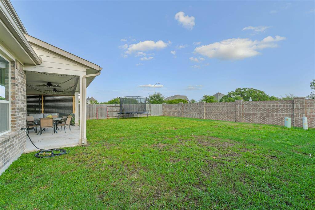 Plenty of space in this yard to add a pool or other outdoor activities, with full gutters and a sprinkler system.