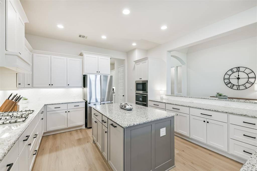 Imagine cooking in this gorgeous and functional kitchen, with its abundant counterspace and specialty cabinets - pots and pan drawers, trash drawer, upgraded vent hood - plus a double oven, island, and gas cooktop.