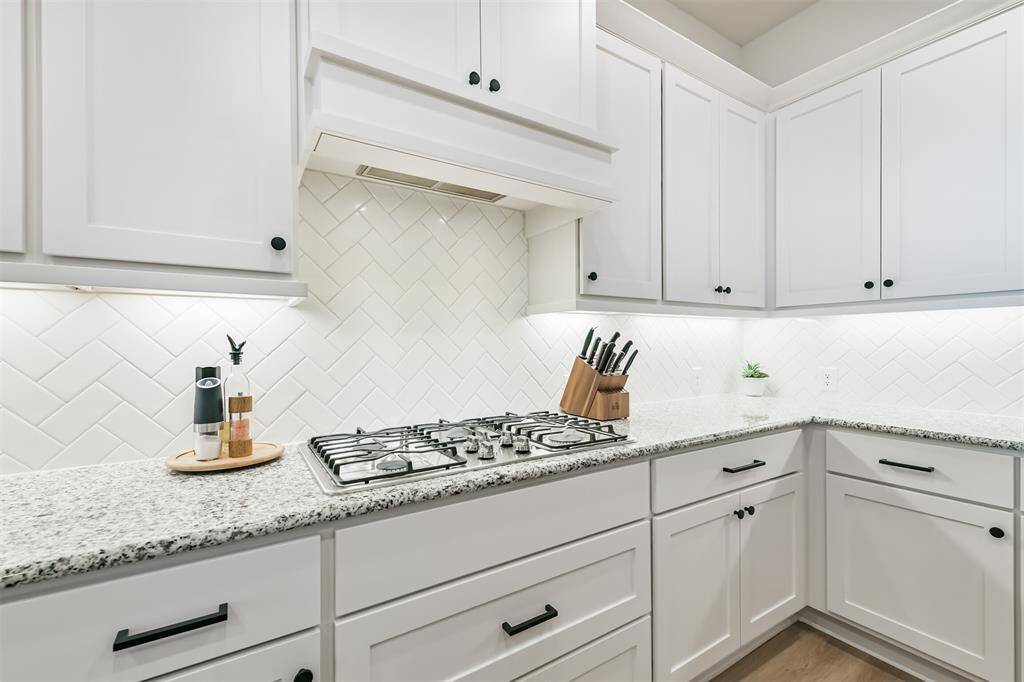 White herringbone patterned backsplash enhances the look of this kitchen with its white cabinets and granite counters - so clean and fresh!