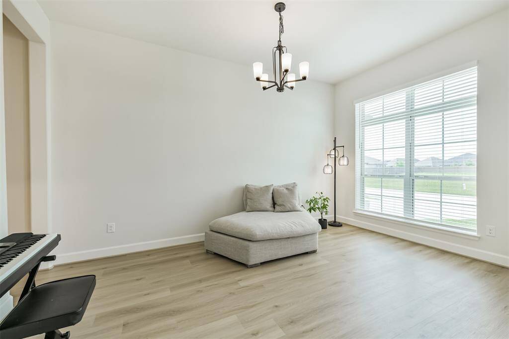 Formal dining looks to the front of the home with upgraded lighting fixture and double windows.