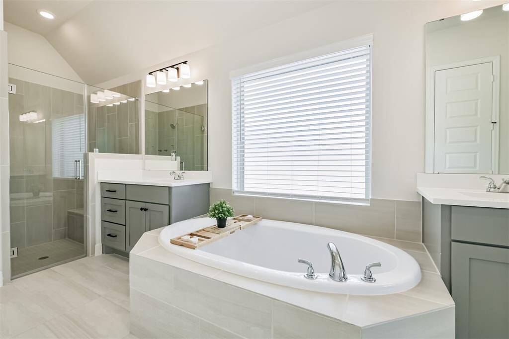 Large soaking tub and frameless glass shower with seat provide luxury when getting ready or relaxing after a long day.