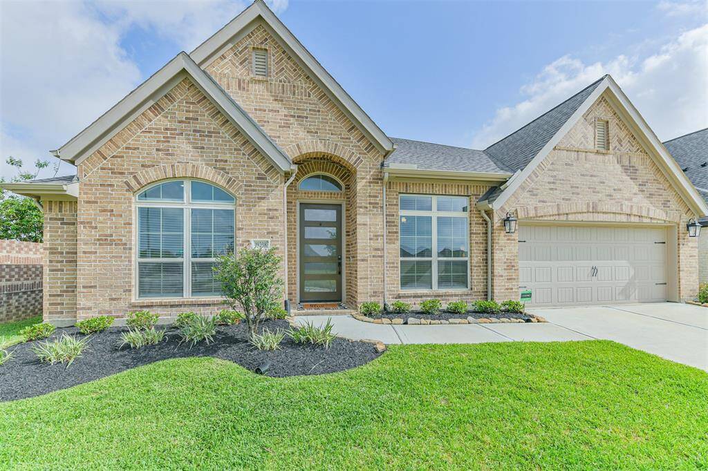 Landscaped beds, bricked front porch, and a gorgeous door add to the curb appeal of this home.