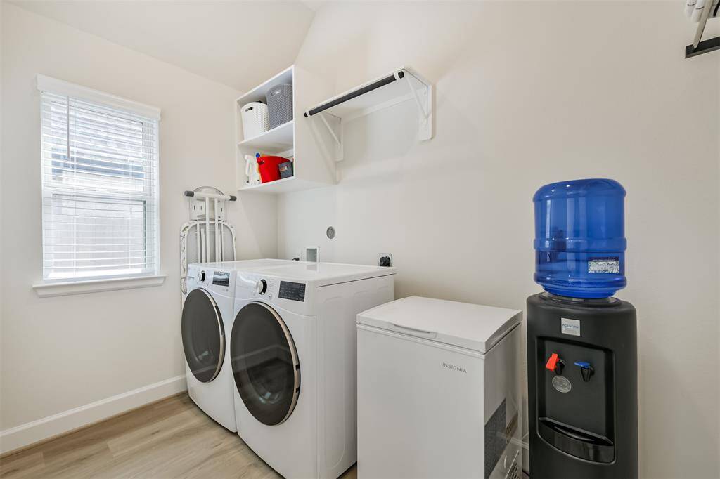 Oversize laundry room with space for a refrigerator and room to hang laundry.