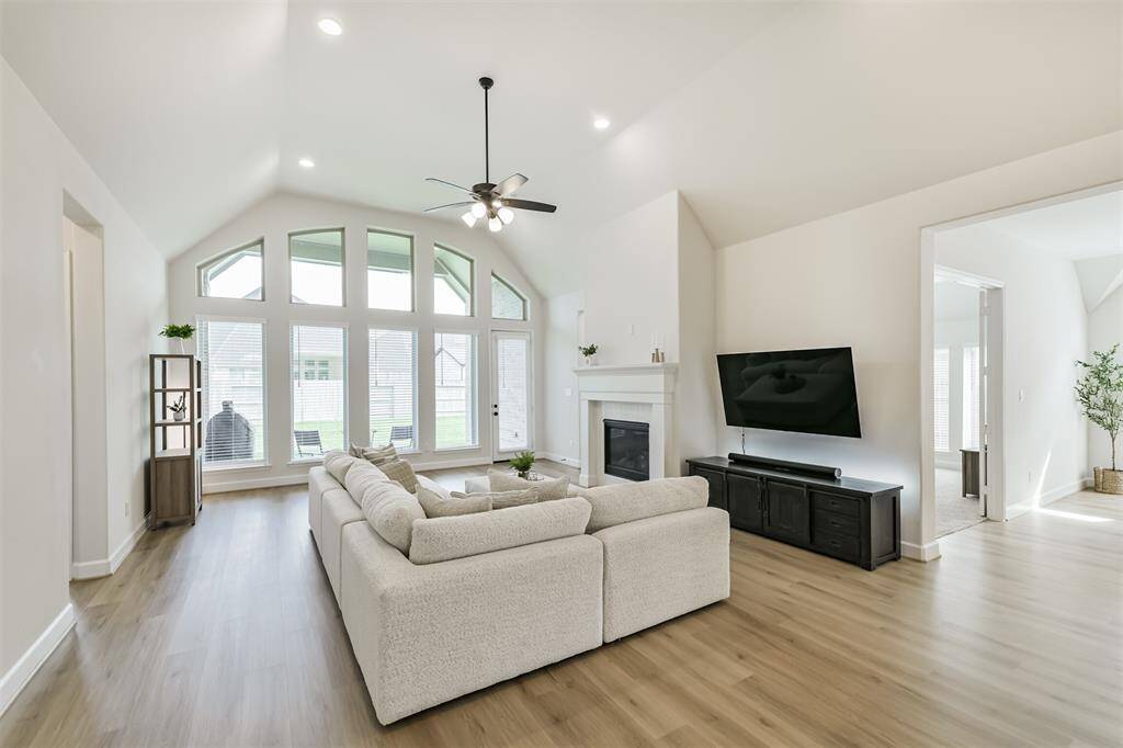 The gallery windows and vaulted ceiling elevate this living room with its gaslog fireplace, added LED lighting, and LVP flooring.