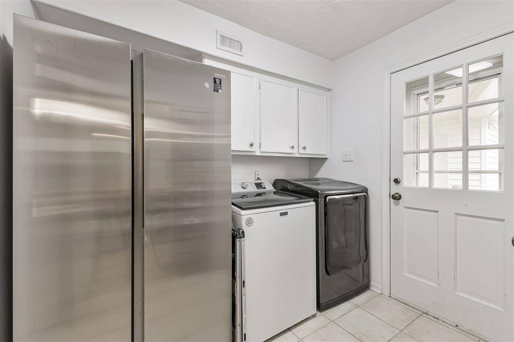 Through the door in the eat-in area is the utility room with a door leading to the side of the home.