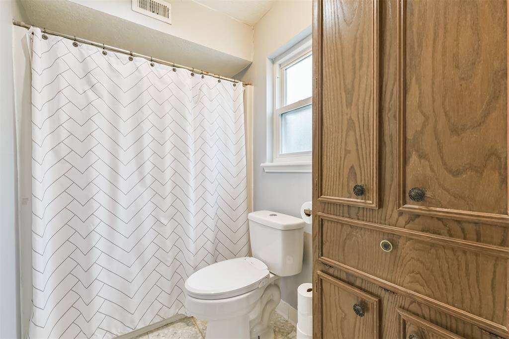 In the bathroom find more storage and a tub-shower combo.