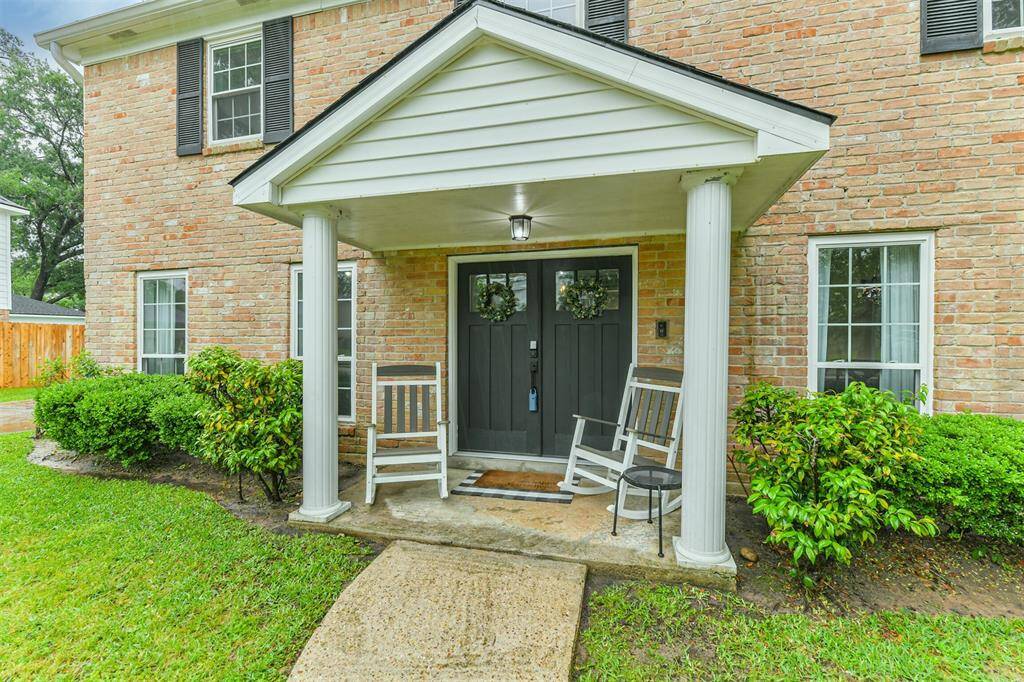 Quaint front porch with double door entry.