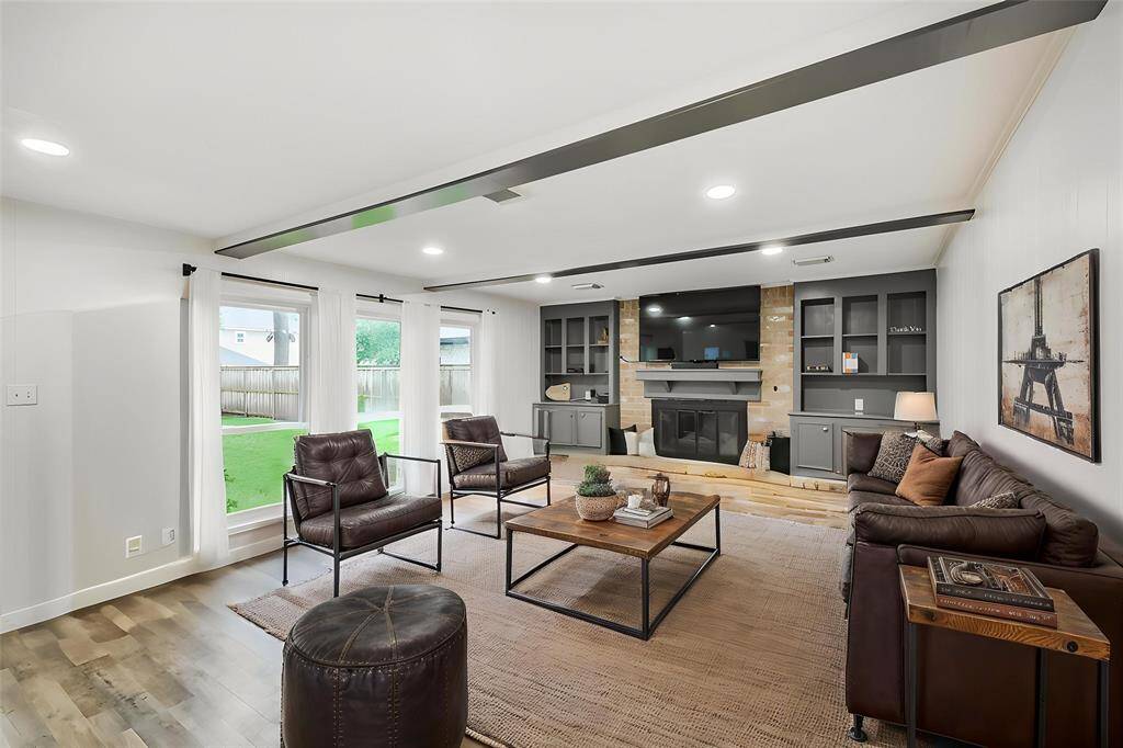 Sneak peek of the living room, anchored by the gas fire place that is flanked by built-in shelves.*Virtually staged*