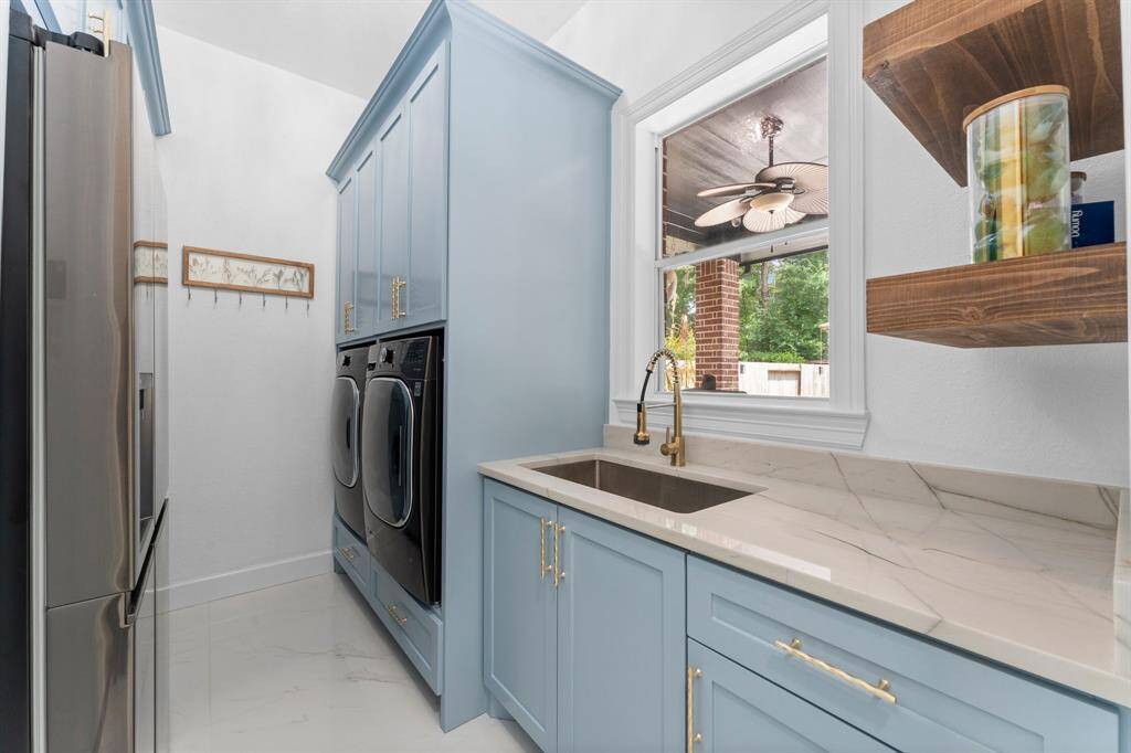 Beautiful laundry room with full sink, refrigerator, washer and dryer.  Tons of storage space.