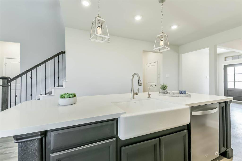 This kitchen with its extended island and farmhouse sink is truly the heart of the home, open to formal dining and living rooms.