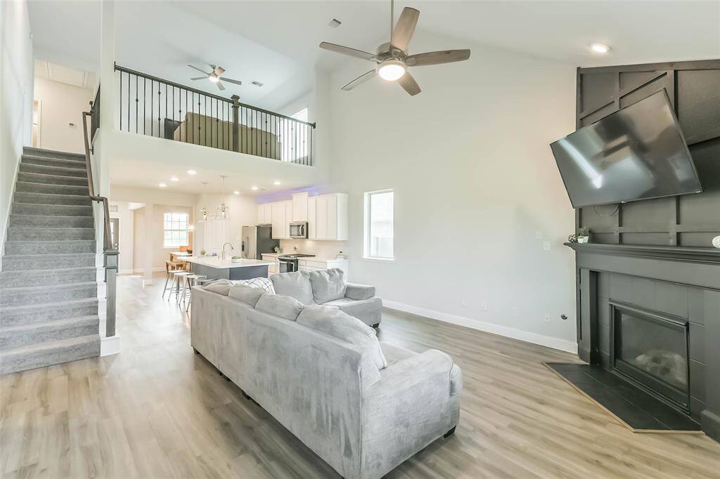 Game room balcony overlooks the living room with its accented fireplace.