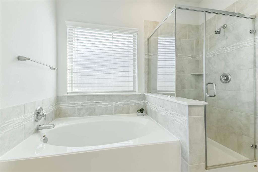 Soaking tub and glass enclosed shower give options for getting ready or relaxing after a long day.