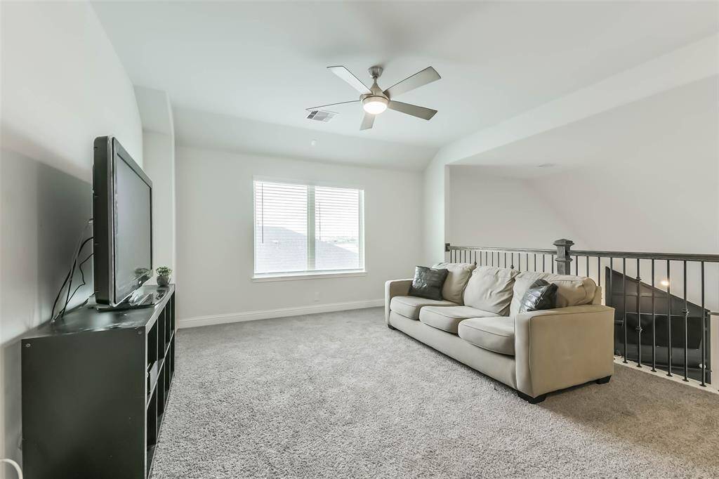 Game room with iron spindles and ceiling fan