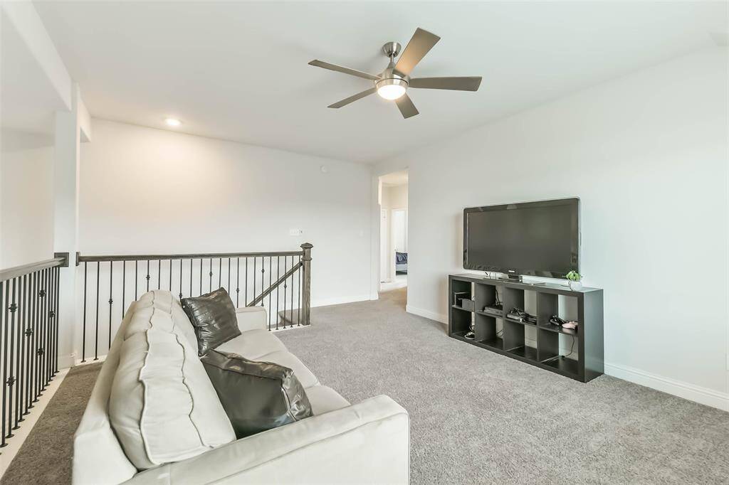 Game room upstairs provides extra relaxation or entertainment space, with iron spindles and ceiling fan.