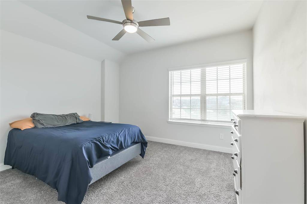 Large third bedroom with double windows and ceiling fan.