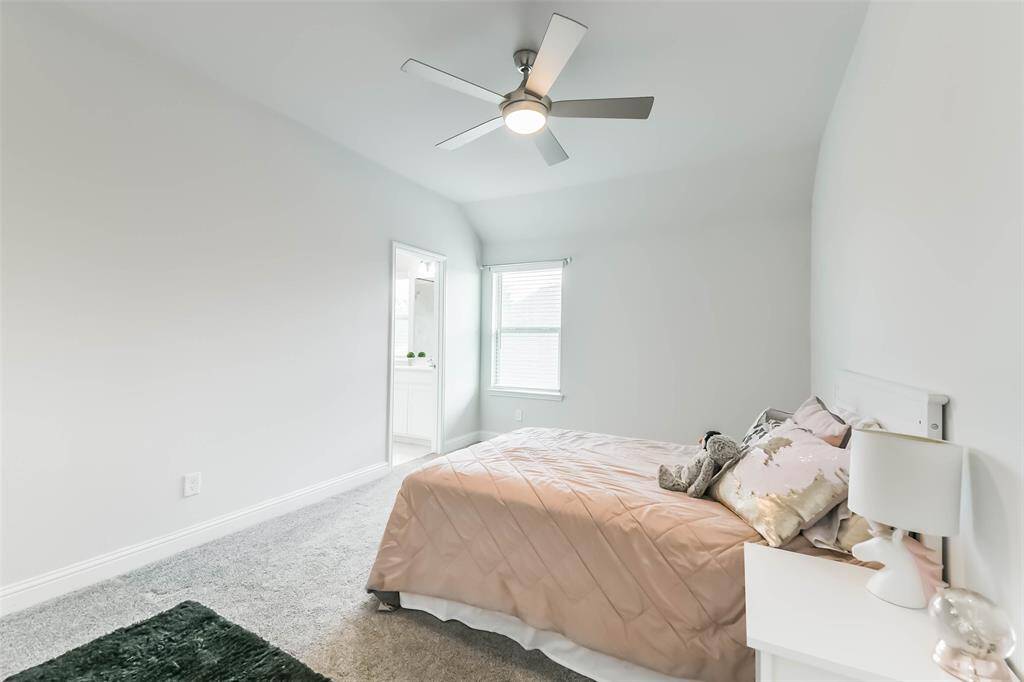 Spacious fourth bedroom with ceiling fan and ensuite bath.