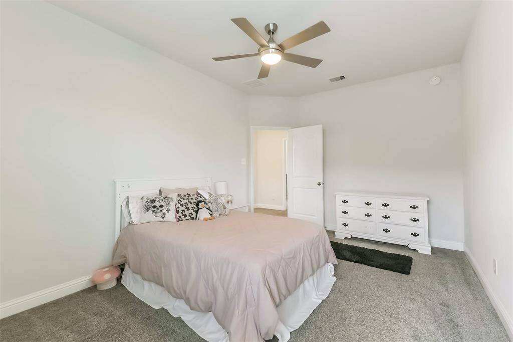 Spacious fourth bedroom with ceiling fan and ensuite bath.