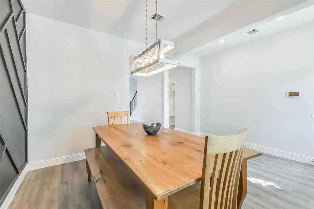 Spacious formal dining room with upgraded light fixture and accent wall.