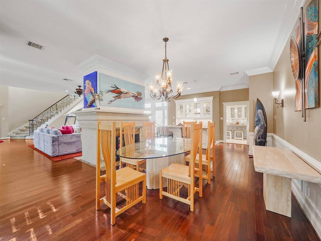 A luxurious chandelier hangs gracefully above, adding a touch of opulence and complementing the refined aesthetic of this exceptional dining space.  Adjacent to the dining area, a well-appointed butler's pantry provides additional storage and convenience, while exquisite china cabinets offer a stylish display for your finest dinnerware.