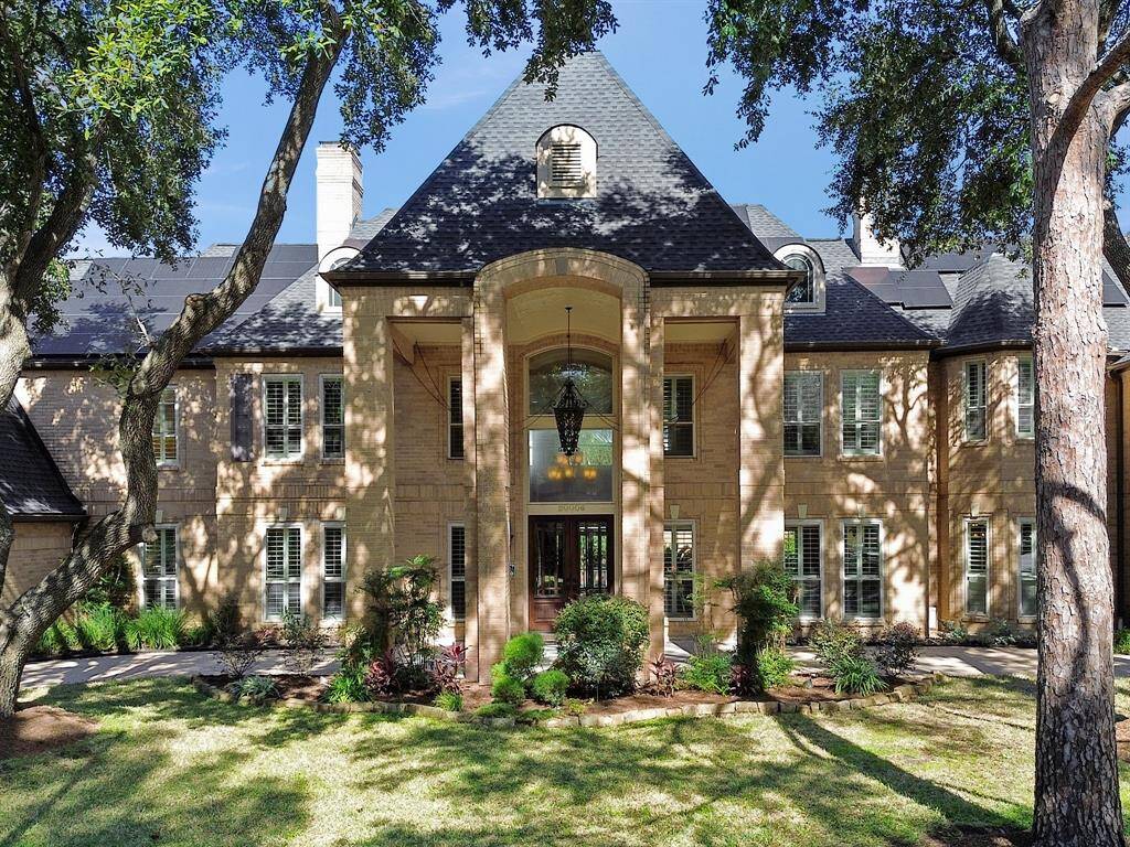 The stately façade features a graceful circular driveway, providing ample parking and a grand approach to the home. Lush landscaping and mature trees surround the property, creating a serene and inviting atmosphere. The impressive two-story columns at the front entryway not only enhance the architectural beauty but also set the tone for the luxurious living spaces that await within.