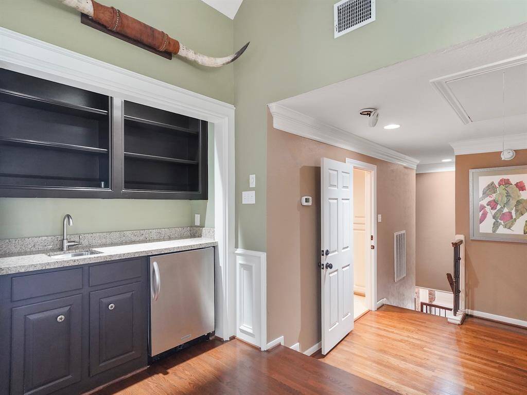View of the wet bar with refrigerator and ample storage!