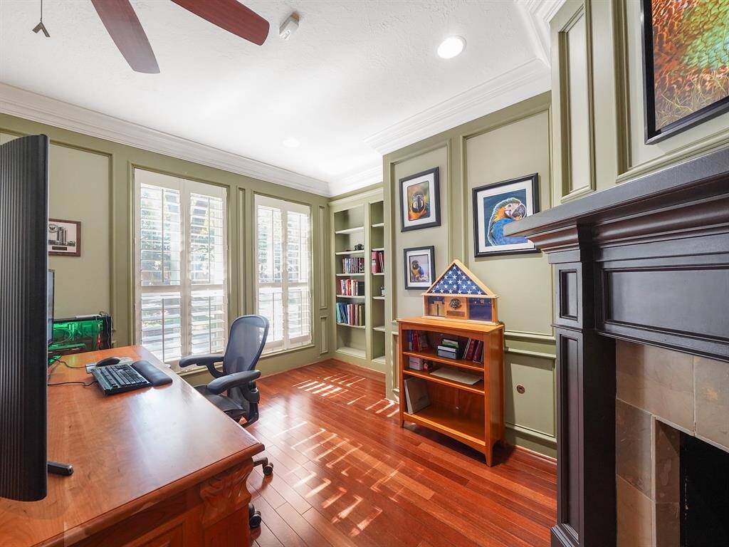 This elegant private office, located to the left of the entrance, features exquisite wainscoting and crown molding. It is beautifully appointed with built-in bookcases and a charming fireplace, creating an ideal space for productivity and inspiration.