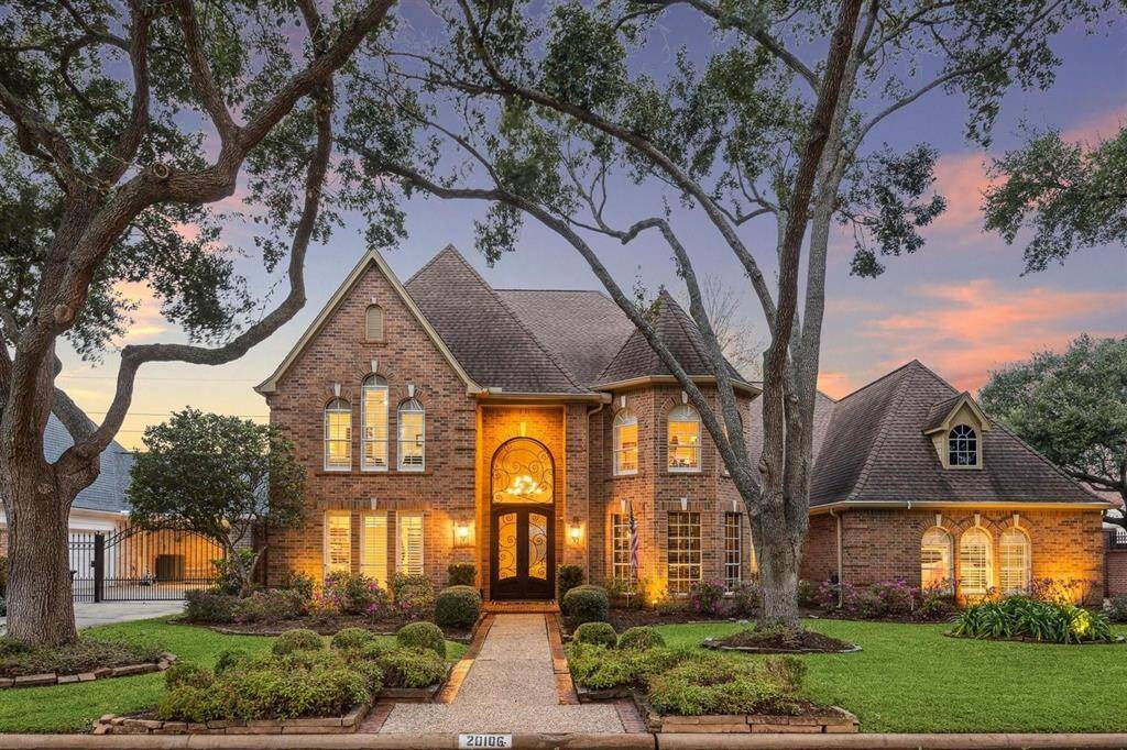 Welcome home to timeless elegance and curb appeal galore! This captivating two-story brick beauty is framed by mature trees, lush landscaping, and glowing evening lights. The arched wrought iron double doors offer a grand entrance, while light-filled windows hint at the luxurious interiors within. A classic yet inviting façade perfect for those who value architectural charm and neighborhood prestige.