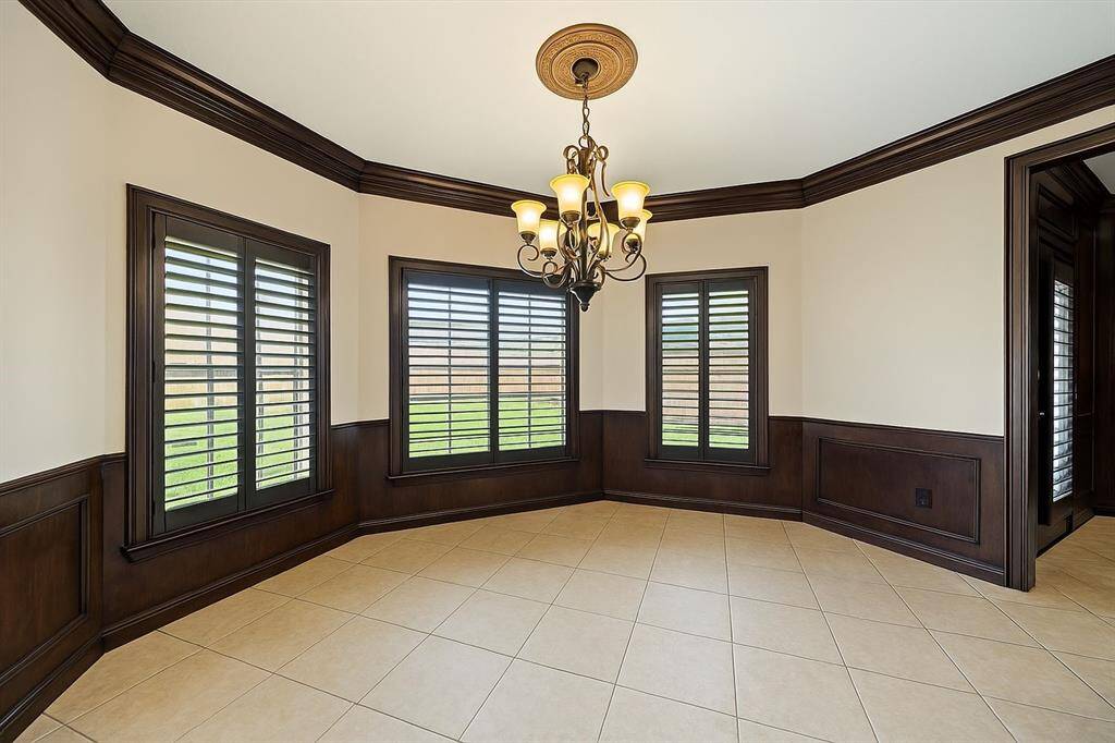 This charming breakfast area is framed by rich trim and multiple shuttered windows, offering an abundance of light and backyard views. The chandelier adds just the right touch of elegance.