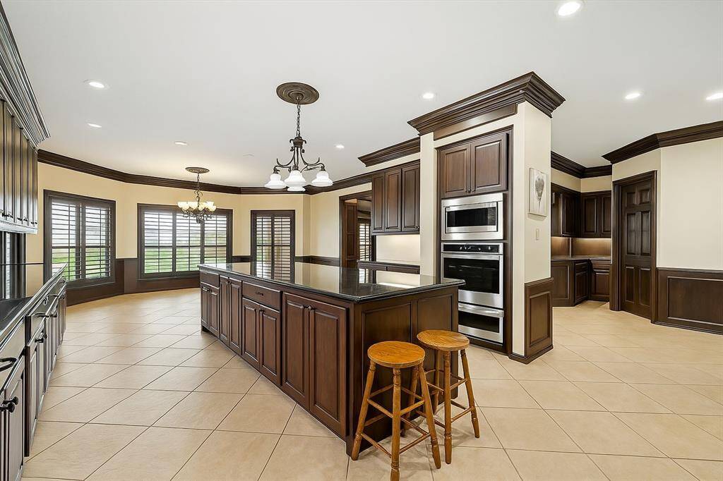 Featuring double ovens, stainless appliances, and a center island with seating, this spacious kitchen is the heart of the home—offering functionality, flow, and timeless finishes.