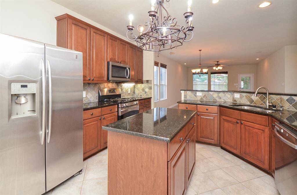 The chef-inspired kitchen is a true showstopper, featuring luxurious granite countertops and a stylish tile backsplash