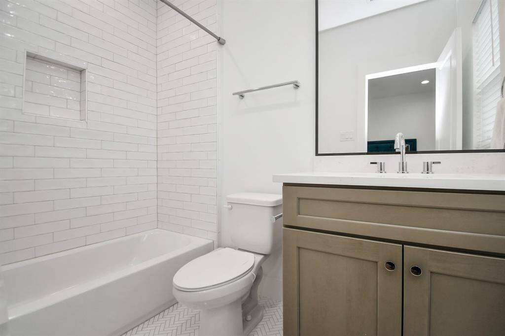 Stylish en-suite bathroom with neutral-toned cabinets contrasting with the light-colored tiles. Although both wall and floor tiles are in a light color, the difference in patterns create a beautiful visual interest, with subway tiles on the wall and hexagon patterns on the floor - talk about details!