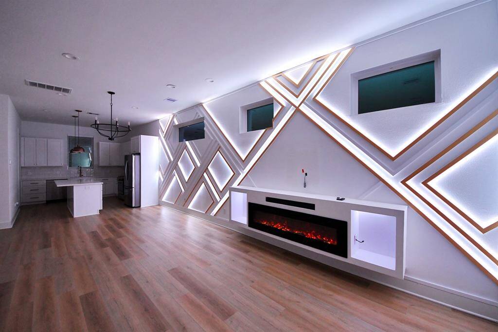 Entertain in style! Living room features a custom LED accent wall with built-in electric fireplace and sound bar. You can easily control the lights on your phone and it comes with multiple settings/colors.
