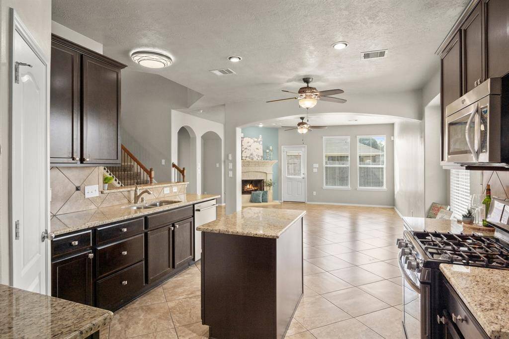 Dark walnut cabinets are right on trend and in beautiful condition. Under-mount sink with pull out faucet. All kitchen knobs, bath fixtures and door hardware coordinate in satin chrome finishes.