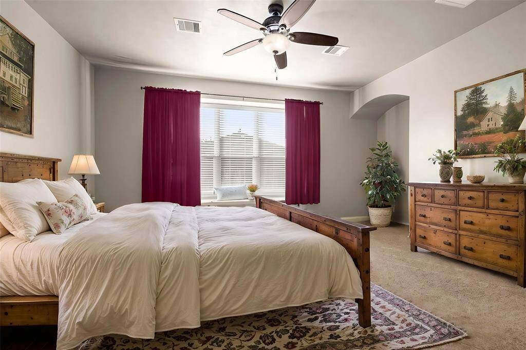Primary suite with cushy carpet, box seat window, ceiling fan, 2" blinds, sitting nook, and gorgeous windows.