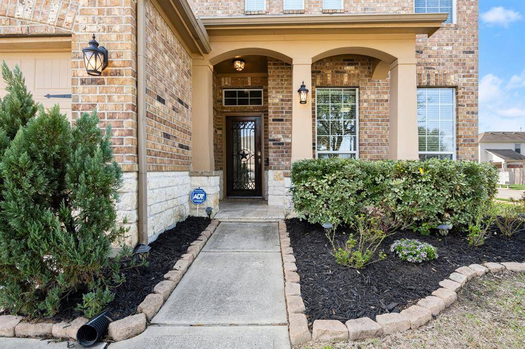Spectacular iron, glass and wood front door has a strong Texas welcome! Enjoy the front porch and note the pretty sconces... there is a lot to like about this home.