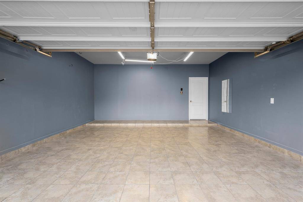 Garage has options... floor is tiled, walls are nicely painted, specialty lights above... could add to your home's space with an addition of a mini-split, workout room, man cave, workshop, or go ahead and park your cars.