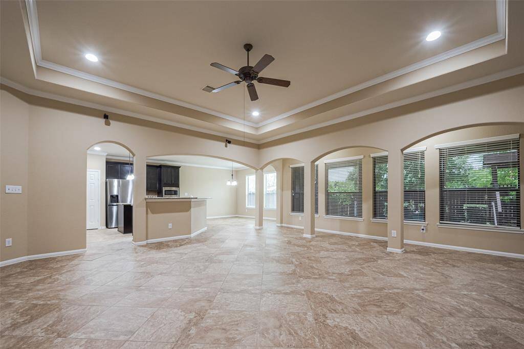 Large open living space perfect for entertaining, with tray ceiling, recessed lighting and outdoor views!