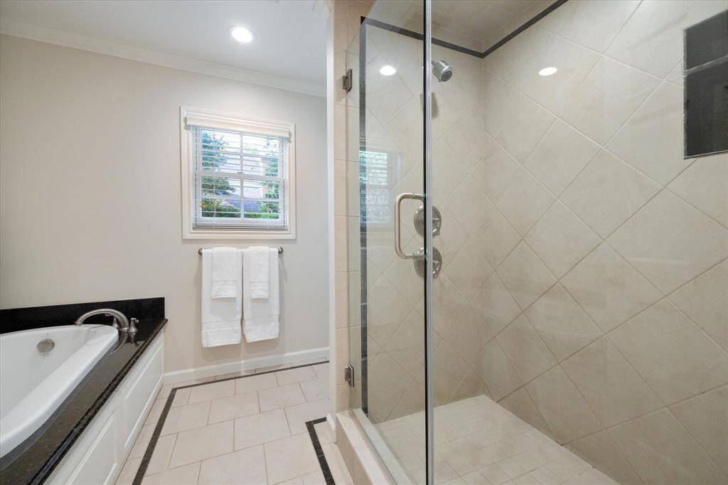 Primary Bath with air jetted tub and shower with shampoo shelf and seat