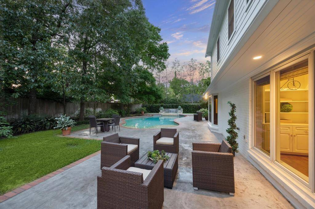 Patio and lush gardens in the backyard by the pool
