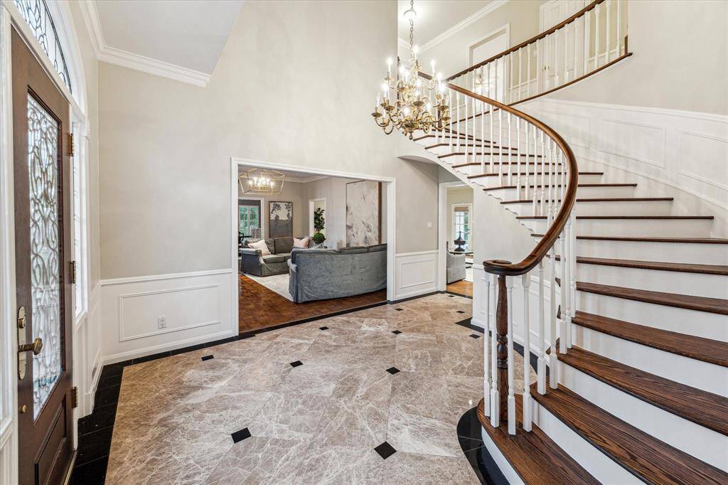 Two story entry with marble and granite floors and sweeping staircase