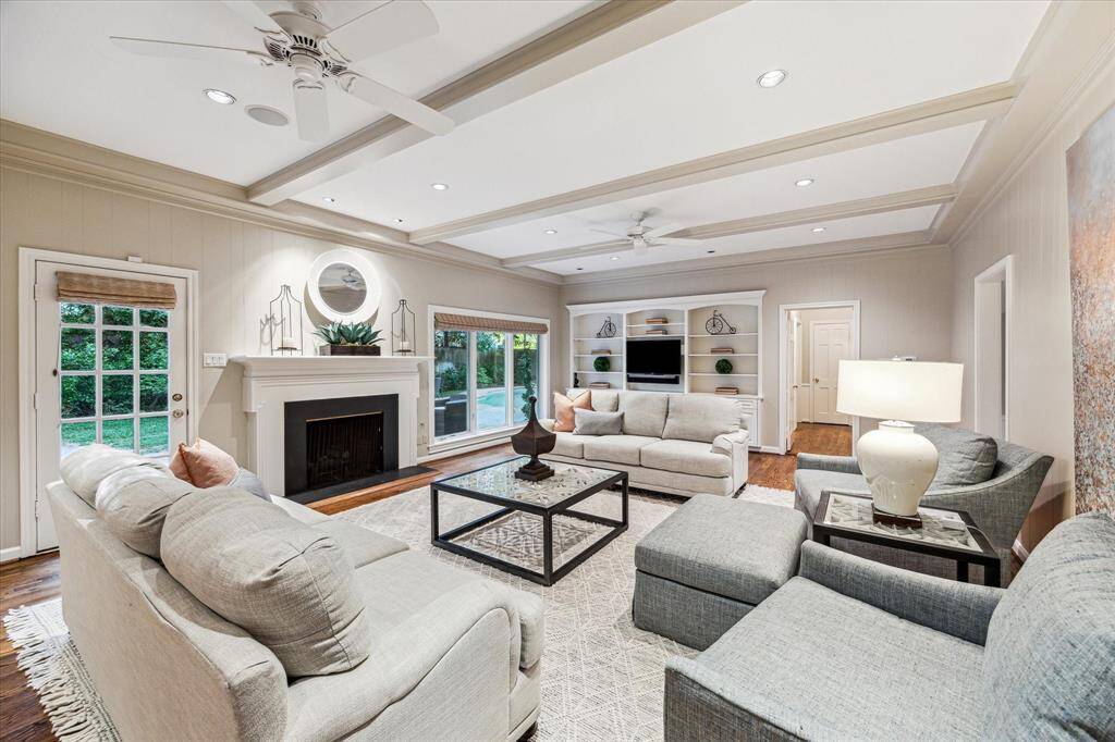 Family Room with gas log fireplace overlooking the back gardens, patio and pool