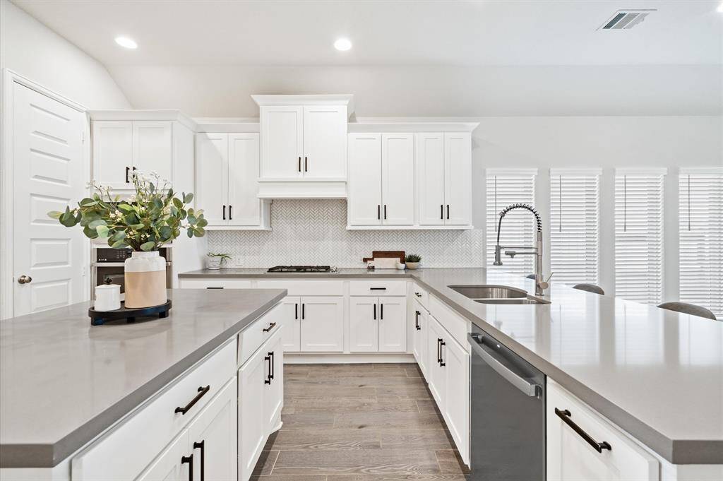 Neutral palette with matte black hardware and gas range.