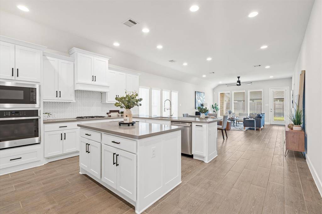 Kitchen boasts granite counters, stainless appliances, recessed lighting and custom backsplash.