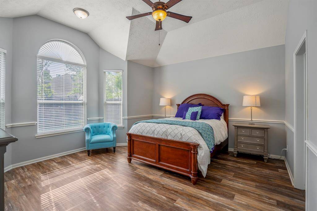Stepping into the spacious primary suite, you’re greeted by gleaming floors, vaulted ceilings, and a charming bay window sitting area that invites relaxation. Chair railing adds a touch of elegance, while the generous layout offers plenty of room to unwind.