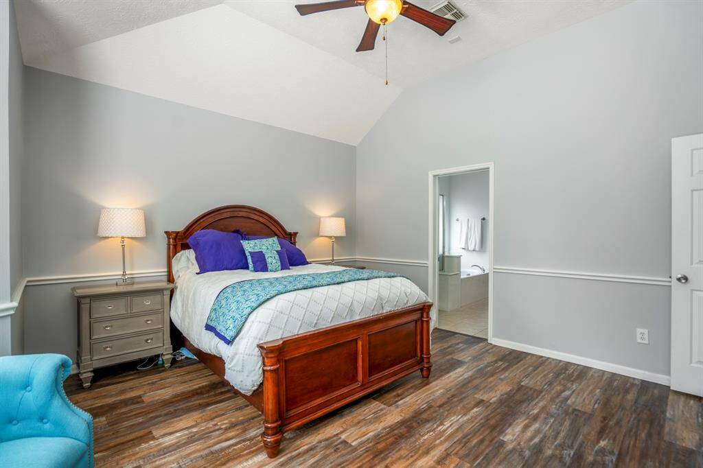 This view of the primary bedroom offers a glimpse into the en suite bath, showcasing the seamless flow and thoughtful layout of this serene retreat.