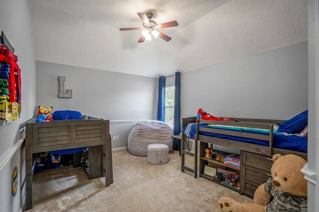 This spacious secondary upstairs bedroom offers plenty of room to spread out, featuring vaulted ceilings and charming chair railing. The large walk-in closet provides ample storage space, making this room as functional as it is beautiful.
