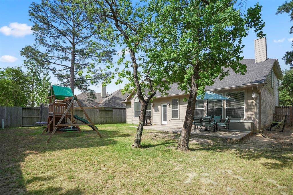 This angle highlights the spaciousness of the yard, offering plenty of room for outdoor activities, gardening, or relaxing under the shade of mature trees.