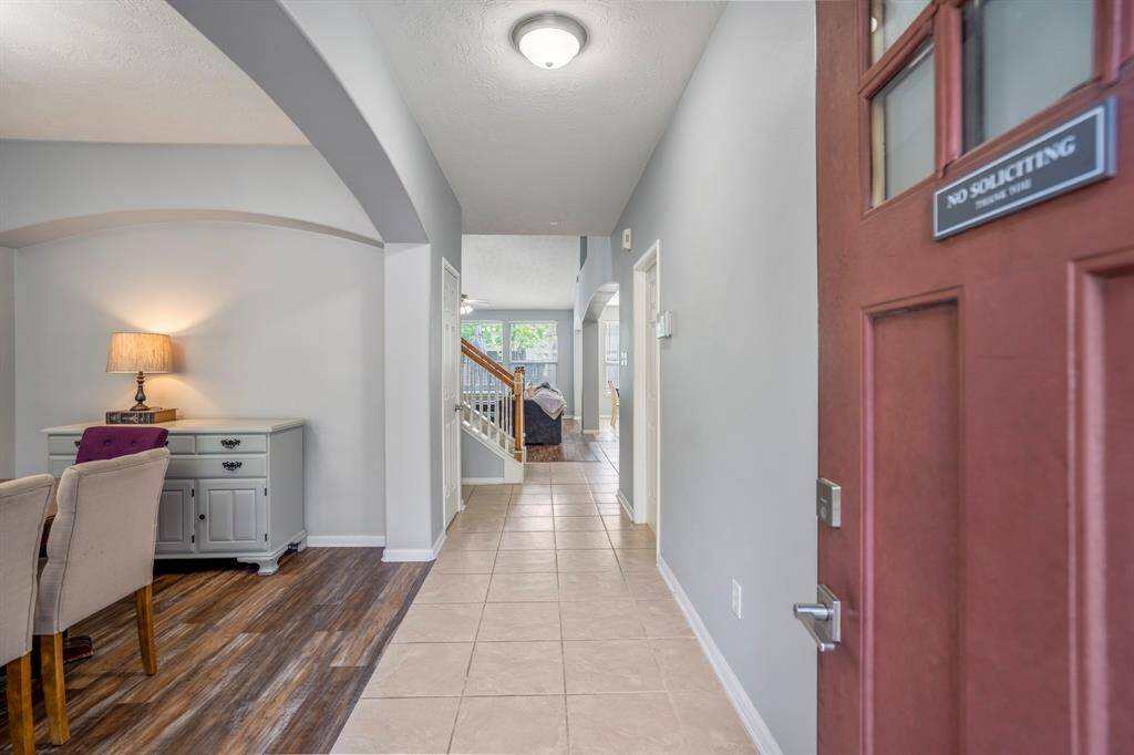 Stepping inside, you're greeted by a spacious entryway with a dramatic archway leading to the formal dining room. Straight ahead, the inviting living room opens up, offering a bright and airy space for gathering.